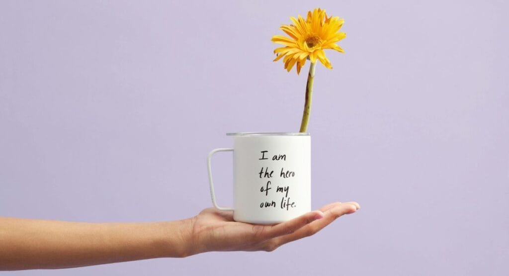 hand holding a cup with new month quotes